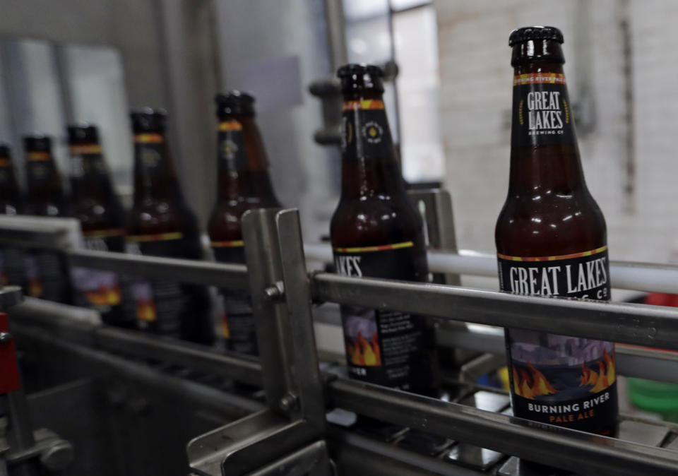 Bottles of Burning River beer make their way down the assembly line in the bottling process at the Great Lakes Brewing Company, Monday, June 17, 2019, in Cleveland. The "burning river" in the beer's name is inspired by the Cuyahoga River’s most famous fire. (AP Photo/Tony Dejak)