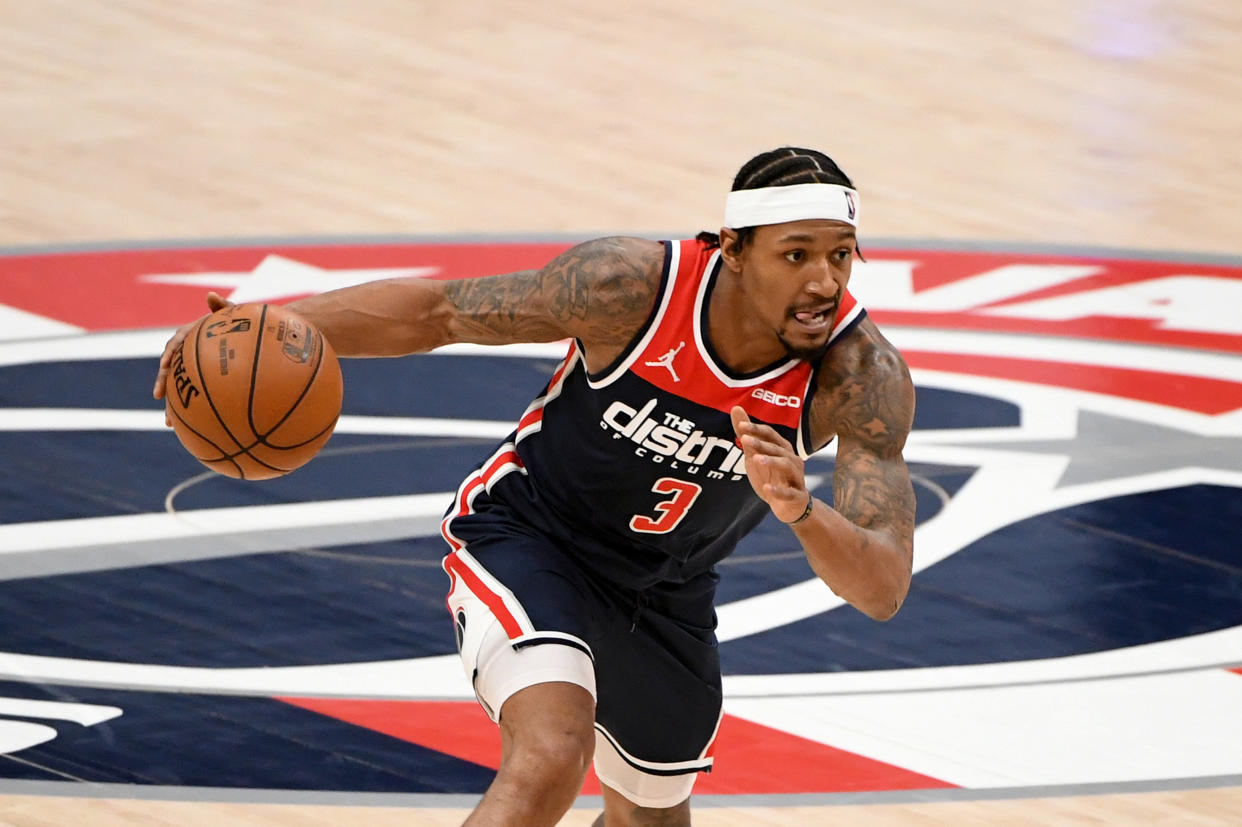 Bradley Beal dribbles with one hand as he leans into a drive. 
