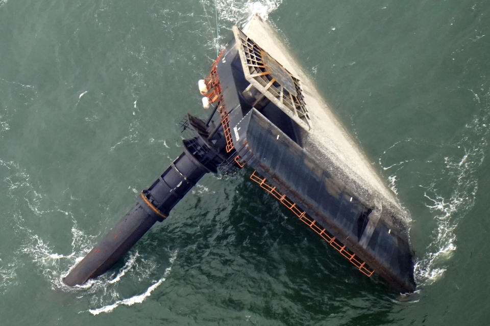 FILE- In this April 18, 2021, file photo, the capsized lift boat Seacor Power is seen seven miles off the coast of Louisiana in the Gulf of Mexico. The lift boat had lowered its legs and was trying to turn to face heavy winds when it flipped in the Gulf of Mexico off Louisiana last month, according to a preliminary federal report released Tuesday, May 18, 2021. (AP Photo/Gerald Herbert, File)