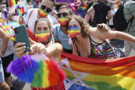 People take part in the Christopher Street Day (CSD) parade, in Berlin, Saturday, July 24, 2021. The official motto of the CSD is "Save our Community - save our Pride". (J'rg Carstensen/dpa via AP)