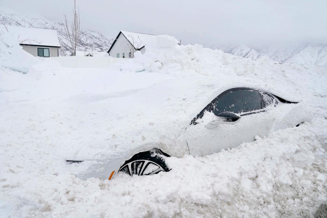 An abandoned electric car is buried in snow in Draper, Utah, on February 23, 2023 (AFP via Getty Images)