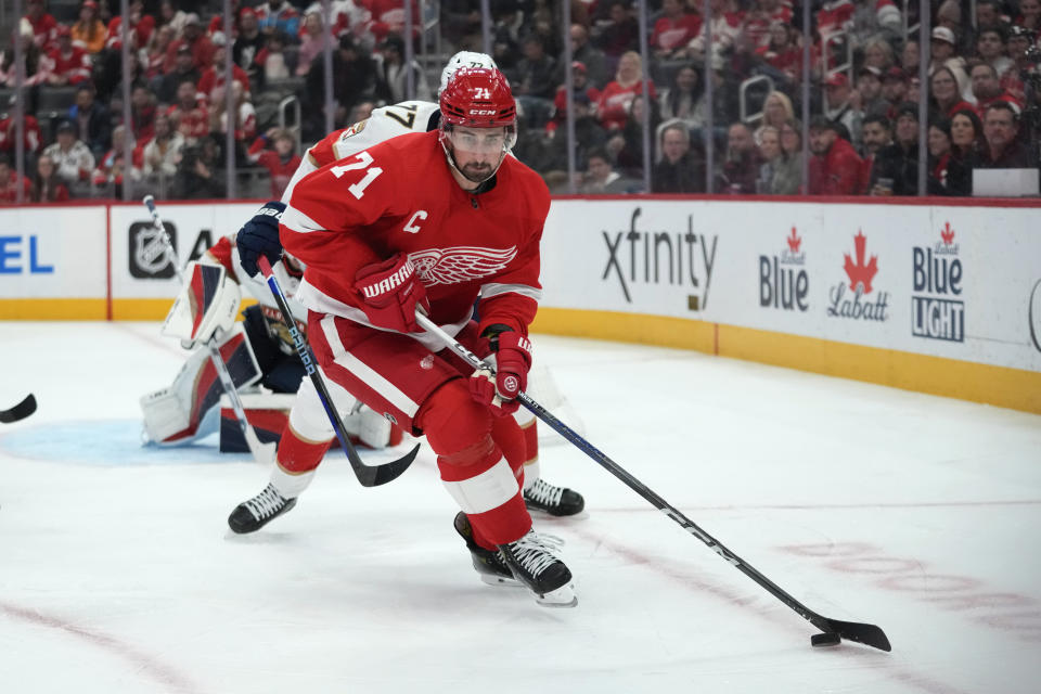 Detroit Red Wings center Dylan Larkin (71) protects the puck from Florida Panthers defenseman Niko Mikkola (77) in the second period of an NHL hockey game Thursday, Nov. 2, 2023, in Detroit. (AP Photo/Paul Sancya)