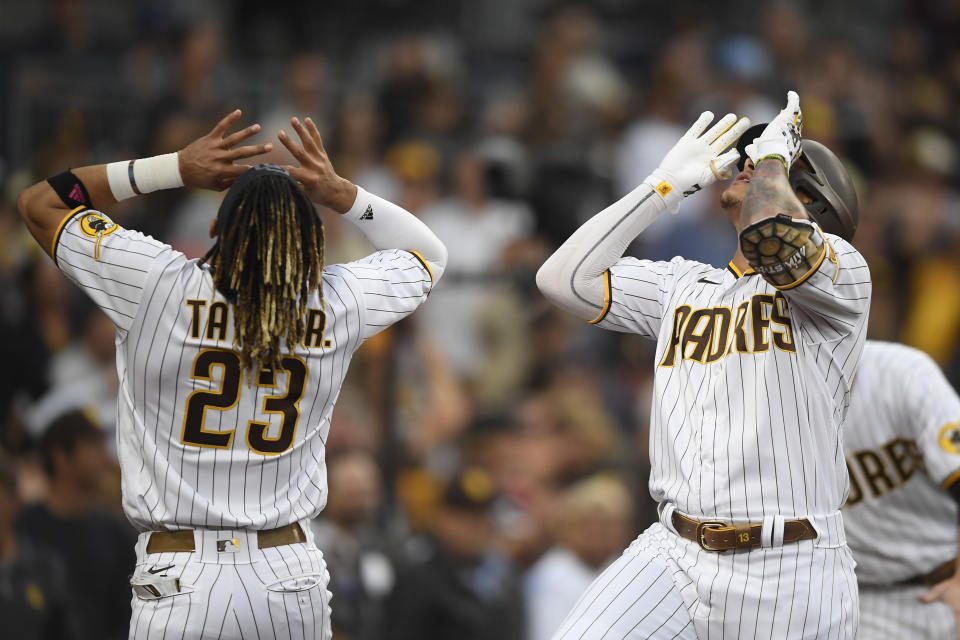 San Diego Padres' Manny Machado (13), right, celebrates with Fernando Tatis Jr. (23) after hitting a solo home run during the first inning of a baseball game against the Los Angeles Dodgers Wednesday, June 23, 2021, in San Diego. (AP Photo/Denis Poroy)