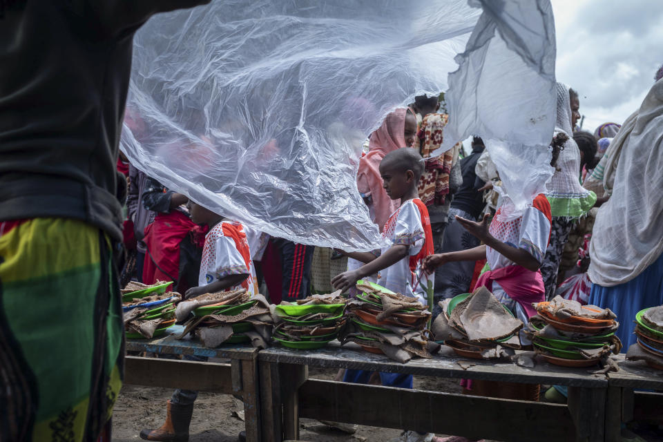 Displaced Ethiopians from different towns in the Amhara region wait for food to be distributed at lunchtime at a center for the internally-displaced in Debark, in the Amhara region of northern Ethiopia Friday, Aug. 27, 2021. As they bring war to other parts of Ethiopia such as the Amhara region, resurgent Tigray fighters face growing allegations that they are retaliating for the abuses their people suffered back home, sending hundreds of thousands of people fleeing in the past two months. (AP Photo/Mulugeta Ayene)