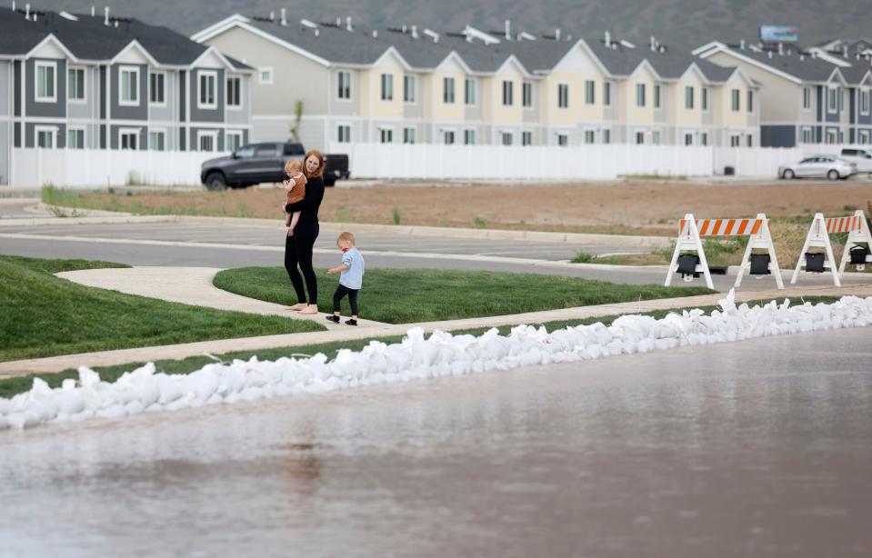 A woman and children walk near flooding in Santaquin on Wednesday, May 17, 2023. | Kristin Murphy, Deseret News