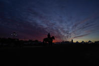 A jockey is seen atop a horse at dawn at the track at Pimlico Race Course ahead of the Preakness Stakes horse race, Wednesday, May 12, 2021, in Baltimore. (AP Photo/Julio Cortez)