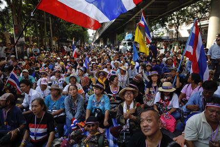 Anti-government protesters sit on the road outside the national police headquarters where they protest in Bangkok November 28, 2013. REUTERS/Damir Sagolj