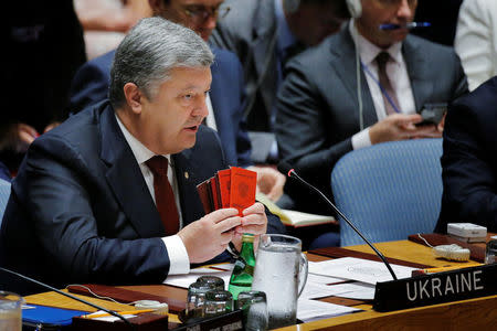 Ukrainian President Petro Poroshenko holds up documents which he says belong to Russian military personnel serving in Ukraine during a meeting of the Security Council to discuss peacekeeping operations during the 72nd United Nations General Assembly at U.N. headquarters in New York, U.S., September 20, 2017. REUTERS/Lucas Jackson