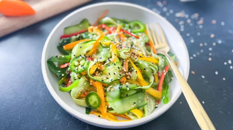 Cucumber bell pepper salad in white bowl