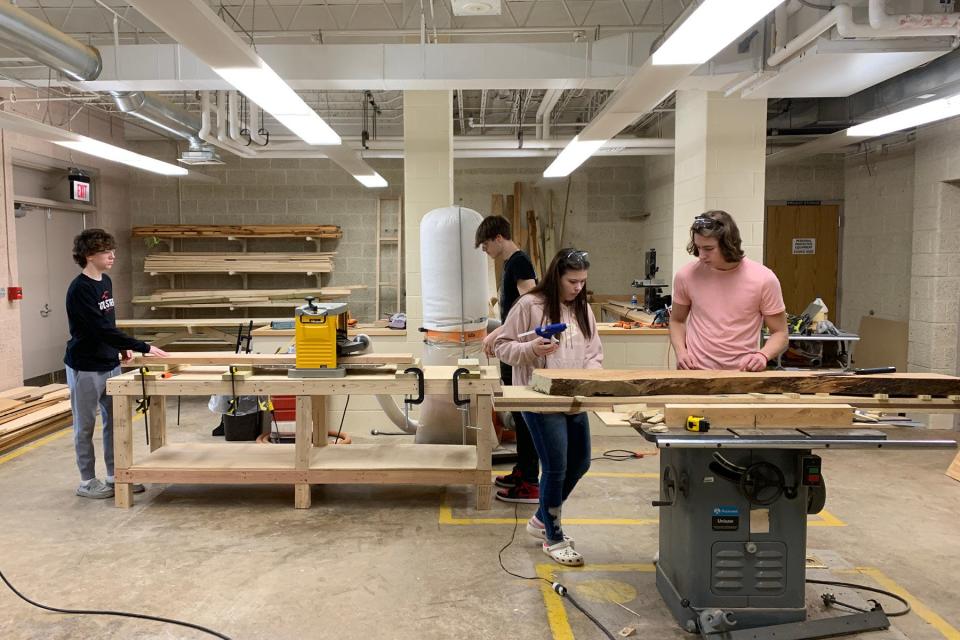 Sebring McKinley students in the carpentry program learn the basics, including the proper handling of tools, as they work their way through a two-year pre-apprenticeship program. Seen here, students in the first-year class work to prepare and plane slabs of wood.