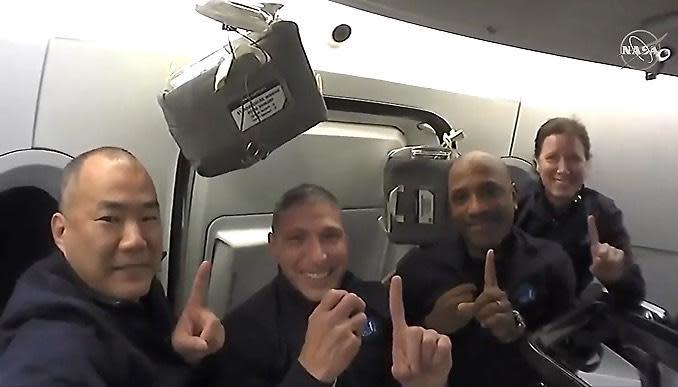 Soichi Noguchi, left, Crew-1 commander Mike Hopkins, Victor Glover and Shannon Walker close out a video tour of their SpaceX Crew Dragon capsule by repeating a phrase they used throughout their training: 
