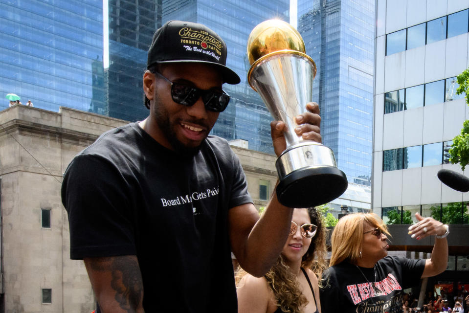 TORONTO, ON - JUNE 17: NBA Finals MVP Kawhi Leonard raises the trophy on top of the bus during the Toronto Raptors Championship parade on June 13, 2019 in Toronto, ON, Canada. (Photo by Julian Avram/Icon Sportswire via Getty Images)