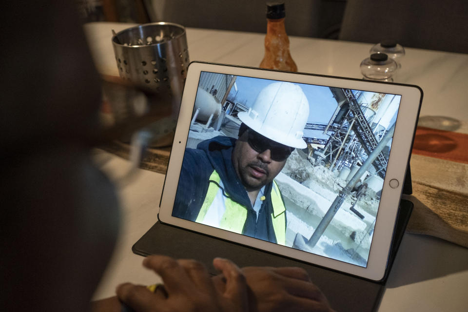 Melanese Marr-Thomas shows photographs of her late husband, Charles Thomas, at work that she keeps on her tablet, at home in District Heights, Md., on Wednesday, Sept. 21, 2022. He worked his way up at his job as a concrete truck driver and became well respected in the company – and within his community, as a known father figure to other Black boys at his youngest son’s football games. He launched a food truck and catering business, Sol Familia Mobile Kitchen, with Melanese. (AP Photo/Wong Maye-E)
