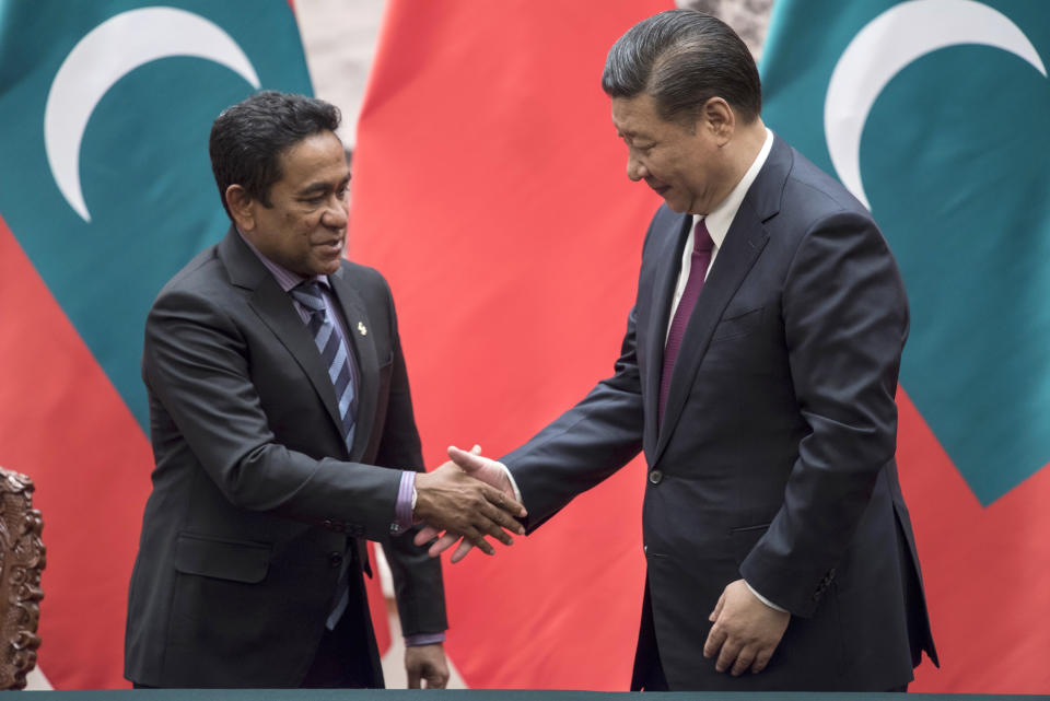 FILE - Maldivian President Yameen Abdul Gayoom, left, shakes hands with China's President Xi Jinping after a signing ceremony at the Great Hall of the People in Beijing on Dec. 7, 2017. China has built up its presence over the years in the Indian Ocean, a key route for its energy supplies, escalating maritime competition between the two Asian giants. Beijing has deepened its engagement mainly through infrastructure deals with India’s neighbors, including Bangladesh, Sri Lanka and most recently the Maldives. (Fred Dufour/Pool Photo via AP, File)