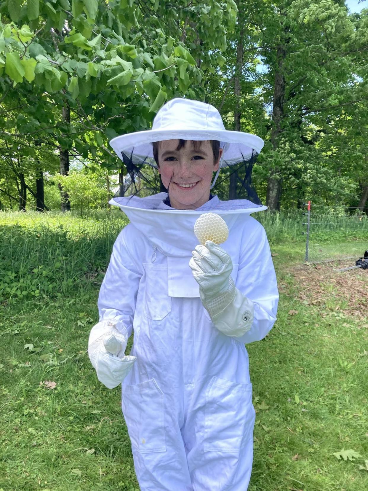 Third-grader Owen Patch holds a piece of honeycomb collected from the Knowlton Academy hive.  (Holly Bailey/Eastern Townships School Board - image credit)