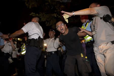 A pro-democracy activist is detained by the police during a confrontation outside the hotel where China's National People's Congress (NPC) Standing Committee Deputy General Secretary Li Fei is staying, in Hong Kong September 1, 2014. REUTERS/Tyrone Siu