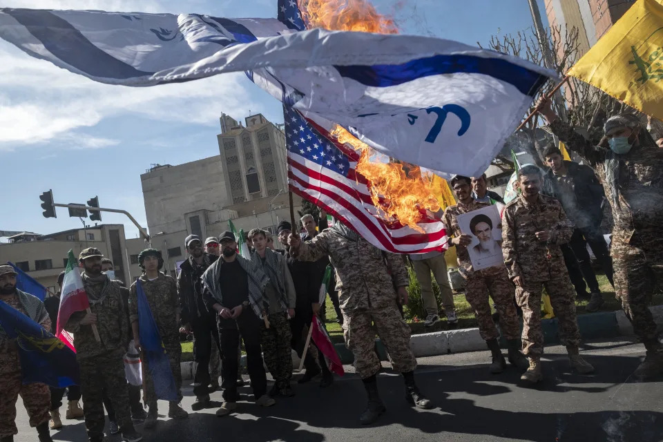 Members of the Islamic Revolutionary Guard Corps (IRGC) burn Israeli and U.S. flags during a funeral for members of the IRGC's elite Quds Force who were killed in an Israeli airstrike in Syria, in Tehran, Iran, April, 2024.  / Credit: Morteza Nikoubazl/NurPhoto/Getty
