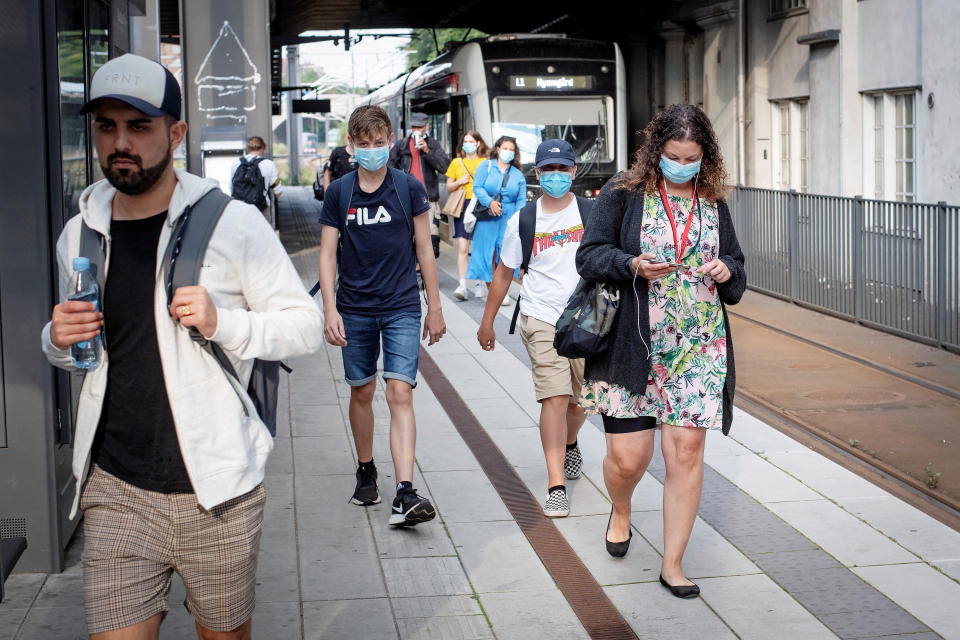 People wearing protective masks wait on a platform in Aarhus, Denmark August 10, 2020. (Ritzau Scanpix/Bo Amstrup via Reuters)