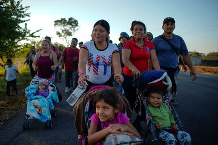 Migrant Celena Mejia (C), from Honduras, pushes a cart with her 6 year-old daughter during their journey towards the United States, in the outskirts of Ciudad Hidalgo, Mexico, January 18, 2019. REUTERS/Alexandre Meneghini