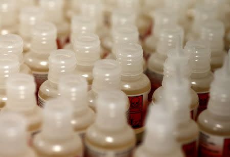 Warning labels are seen on the bottles of flavour concentrate as they are produced at the offices of the British e-cigarette company Totally Wicked in Blackburn, northern England March 19, 2015. REUTERS/Phil Noble