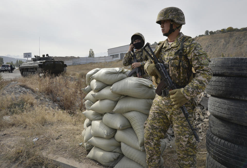 Soldiers of Kyrgyz army stand at checkpoint on city street in Bishkek, Kyrgyzstan, Saturday, Oct. 10, 2020. President Sooronbai Jeenbekov decreed the state of emergency in the capital and ordered the military to deploy troops to Bishkek to enforce the measure. (AP Photo/Vladimir Voronin)