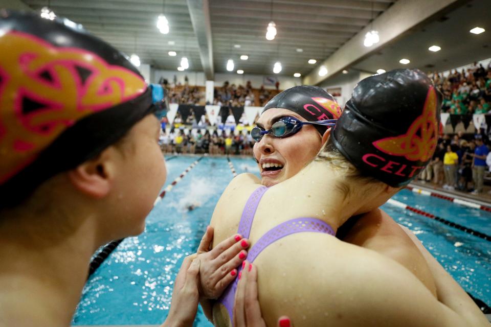 Dublin Jerome’s Libby Grether, center, hugs Zoe Musselman, right, while celebrating with Milly Leonard and Olivia Matson (not pictured) after winning the 400-yard freestlye relay during the Division I state swimming meet Saturday at Branin Natatorium in Canton. The Celtics captured their first team title.