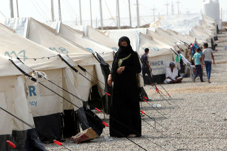 A woman, who fled from Islamic State violence, stands outside a tent at Debaga Camp in the Makhmour area near Mosul, Iraq, August 30, 2016. REUTERS/Azad Lashkari