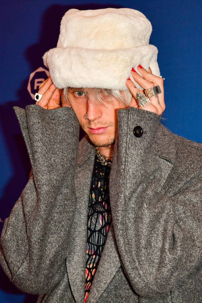 Machine wearing a coat and a furry hat