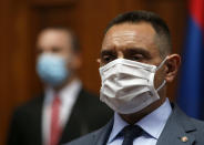 In this Tuesday, April 28, 2020. file photo, Serbia Defense Minister Aleksandar Vulin wearing a mask to protect against coronavirus attends the session in Belgrade, Serbia. The Defense Ministry says Serbia's Defense Minister Aleksandar Vulin has tested positive with the coronavirus. (AP Photo/Darko Vojinovic, File)