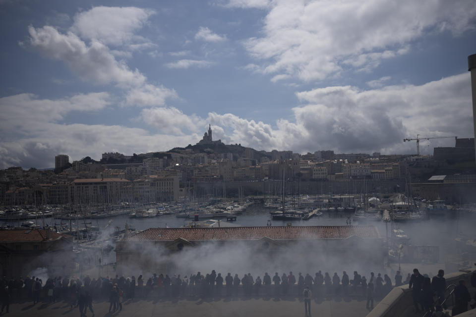 Humo de bengalas cubre el lugar donde se lleva a cabo una manifestación en Marsella, sur de Francia, el jueves 23 de marzo de 2023. Los sindicatos franceses organizaron sus primeras manifestaciones masivas el jueves, luego de que el presidente Emmanuel Macron hizo enojar aún más a sus críticos al mantenerse firme con su plan de reformar el sistema de pensiones que su gobierno ha impulsado en el Parlamento sin someterla a una votación. (AP Foto/Daniel Cole)