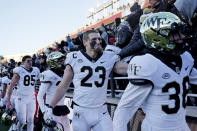 Wake Forest tight end Brandon Chapman (23) joins teammates as they celebrate with fans in the stands after defeating Boston College in an NCAA college football game, Saturday, Nov. 27, 2021, in Boston. (AP Photo/Mary Schwalm)