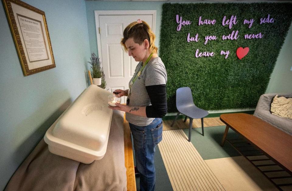 Chloe Robbins, an associate at Pet Memorial Services, sets up a display like one that would be used during a pet memorial service at Wayside Waifs. Proceeds from the services helps to support the shelter’s residents.