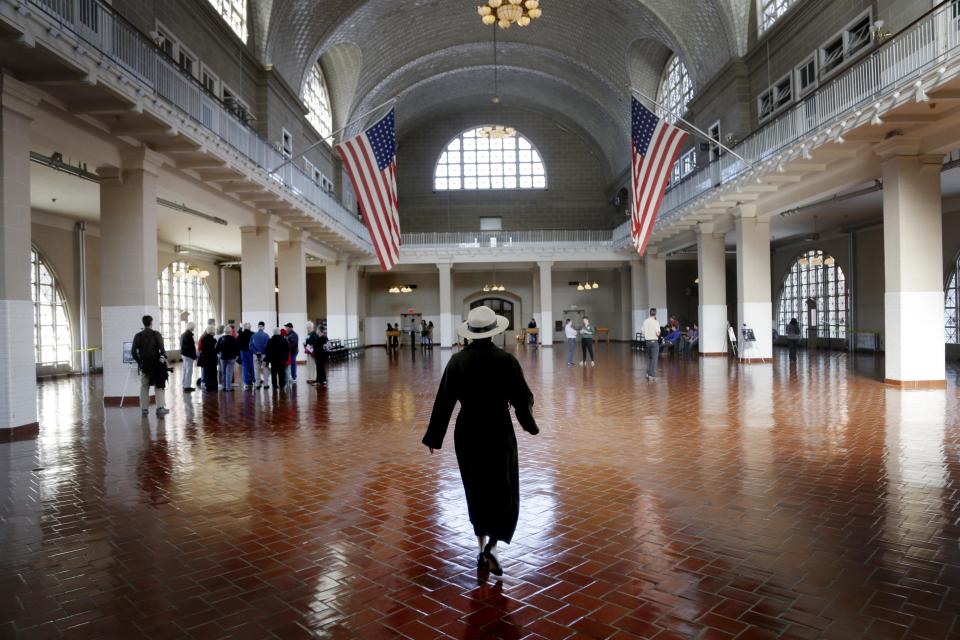 A park ranger walks through the registry room on Ellis Island in New York, Monday, Oct. 28, 2013. The island that ushered millions of immigrants into the United States received visitors Monday for the first time since Superstorm Sandy. Sandy swamped boilers and electrical systems and left the 27.5-acre island without power for months. (AP Photo/Seth Wenig)