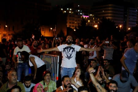 People gesture and chant slogans during a protest over deteriorating economic situation in Beirut