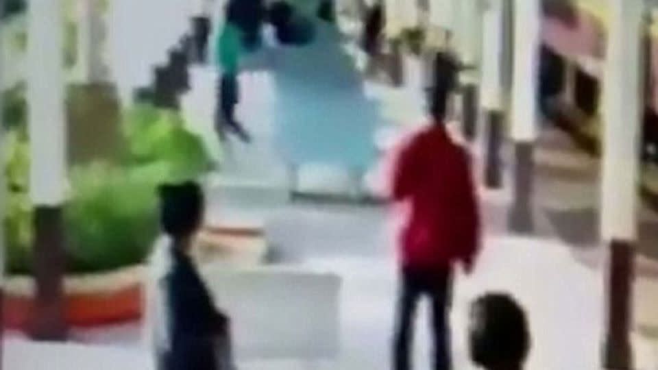 The moment the man, dressed in the green top can be seen running away. Source: CEN