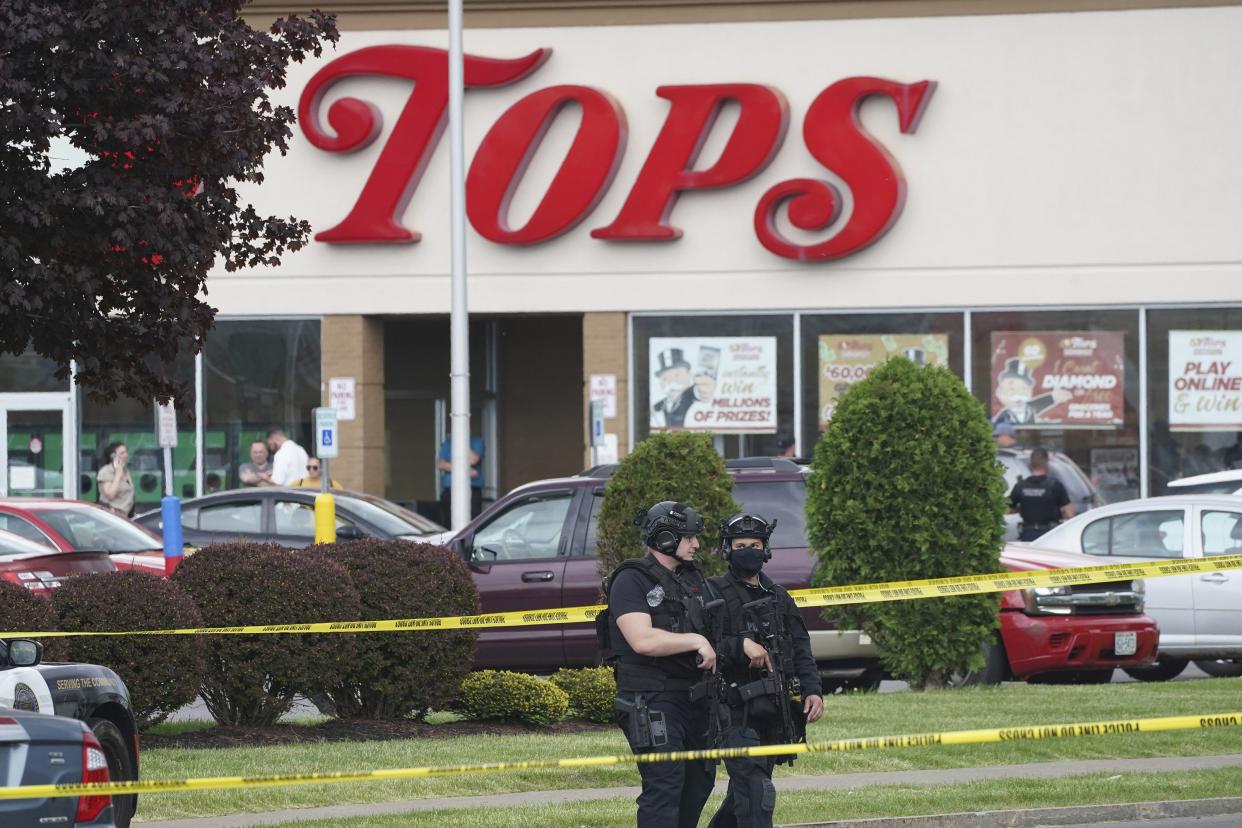 Police secure an area around a supermarket where several people were killed in a shooting on Saturday, May 14, 2022, in Buffalo, N.Y.