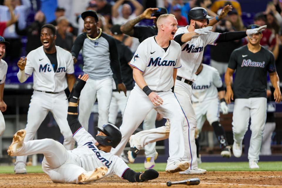 Miami Marlins first baseman Yuli Gurriel (10) scores the winning run against the St. Louis Cardinals as teammates celebrate at loanDepot Park on July 5.