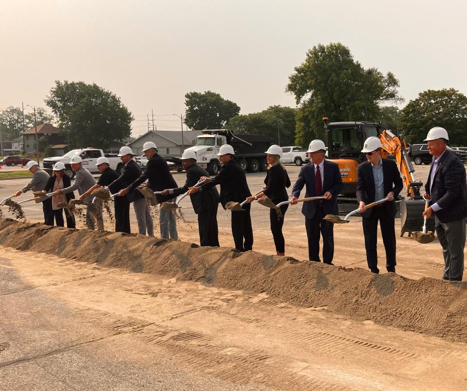 People involved with the creation of a new YMCA of Muncie building adjacent to Muncie Central High School overturn dirt Tuesday during the ceremonial groundbreaking for the facility in the parking lot between the school and the Muncie Fieldhouse.