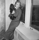 <p>The <em>Rear Window</em> star relaxes with her poodle on the windowsill of her Fifth Avenue apartment shortly before departing to Monaco before her nuptials to Prince Rainier, circa 1956.</p>