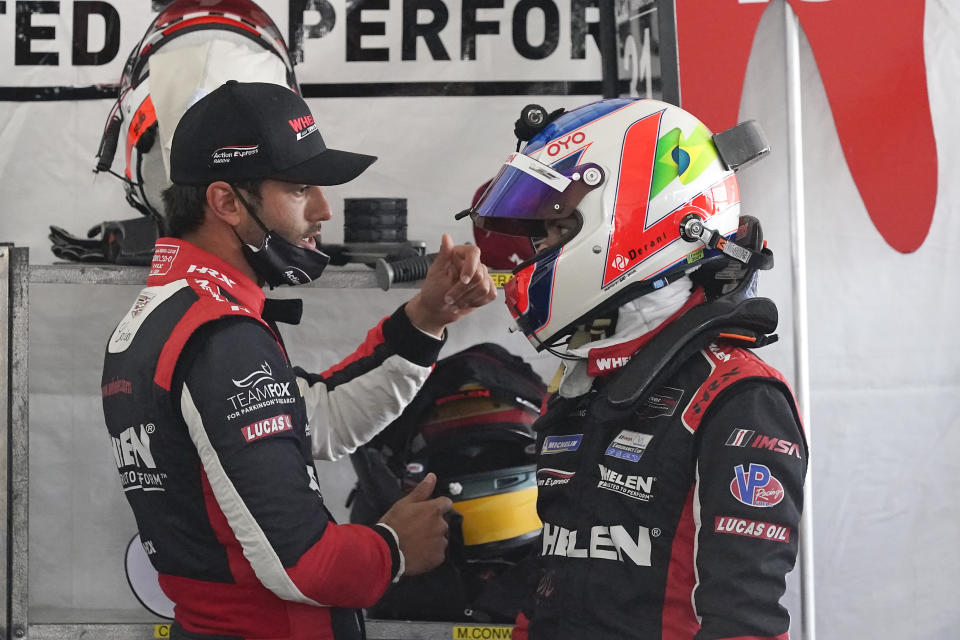 Felipe Nasr, left, and Pipo Derani, both from Brazil, talk in their pit stall during a practice session for the Rolex 24 hour race at Daytona International Speedway, Friday, Jan. 29, 2021, in Daytona Beach, Fla. (AP Photo/John Raoux)