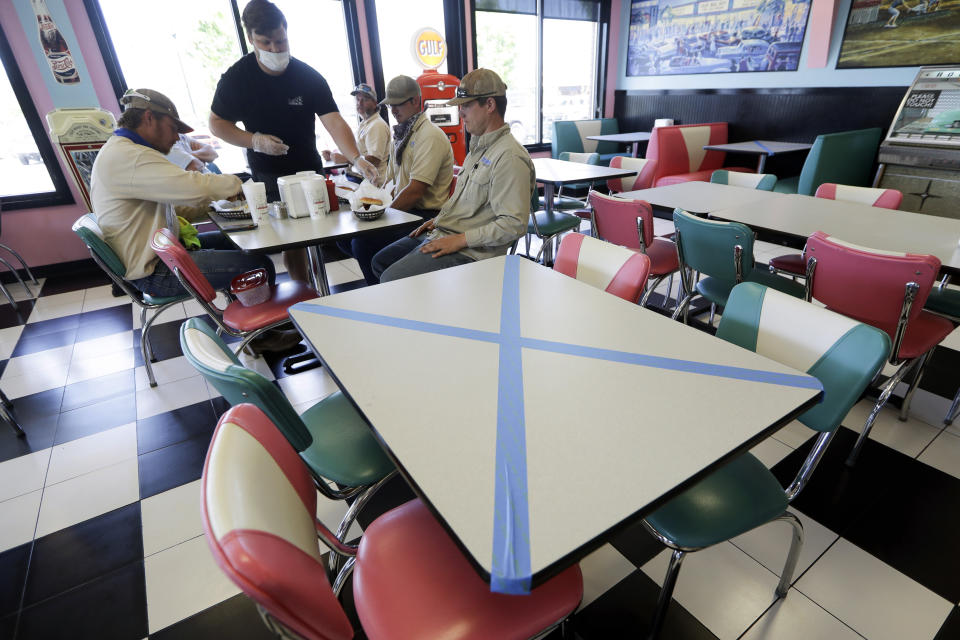 Tables are marked off for social distancing at Hwy 55 Burgers Shakes & Fries Monday, April 27, 2020, in Nolensville, Tenn. Monday is the first day Tennessee restaurants can reopen with reduced seating and social distancing during the coronavirus pandemic. (AP Photo/Mark Humphrey)