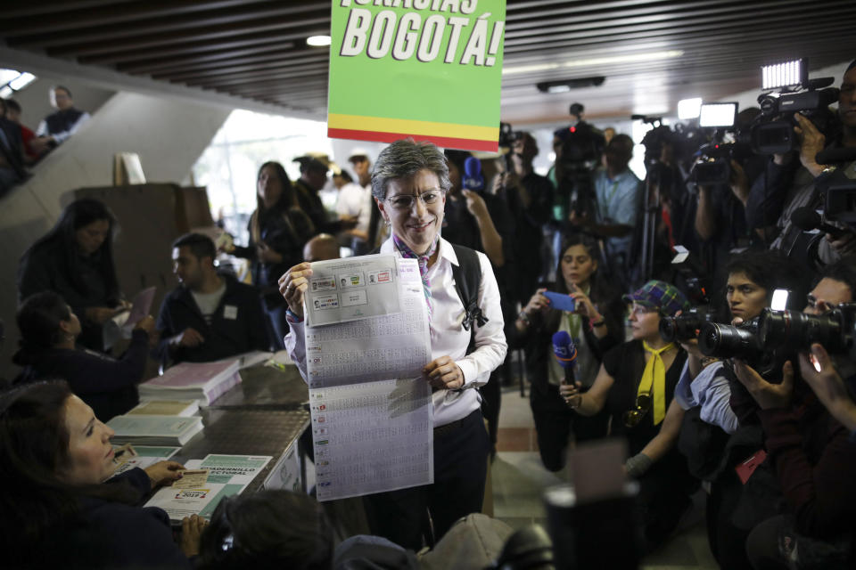 Claudia Lopez, candidate for Mayor of Bogota for the Green Alliance, shows her ballot before voting during local and regional elections in Bogota, Colombia, Sunday, Oct. 27, 2019. Colombians went to the polls Sunday to choose mayors, state governors and local assemblies. (AP Photo/Ivan Valencia)