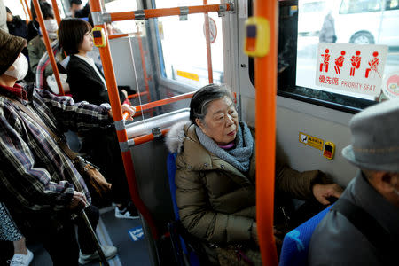 Royal aficionado Fumiko Shirataki, 78, rides on a bus as she heads to the site where a ceremony marking the 30th anniversary of Japan's Emperor Akihito and Empress Michiko's enthronement will be held, in Kawasaki, Japan, February 24, 2019. REUTERS/Issei Kato