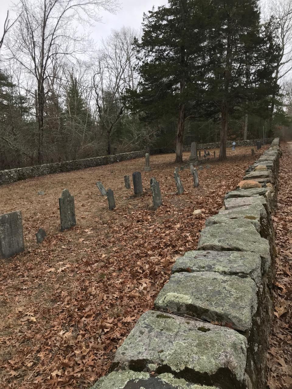 A stone wall forms a perimeter around 28 inscribed stones in a Rathbun family cemetery.