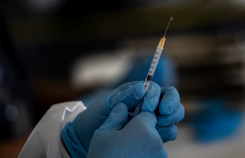 RIVERSIDE, CA - FEBRUARY 2, 2021: A health care professional measures a dose of the Moderna vaccine at a vaccination site in the parking lot of the Riverside Convention Center on February 2, 2021 in Riverside, California. Currently, this site is capable of giving 500 vaccinations a day in one of the regions hardest hit by the pandemic. Only residents 65 and older and educators are eligible for the vaccination here.(Gina Ferazzi / Los Angeles Times)