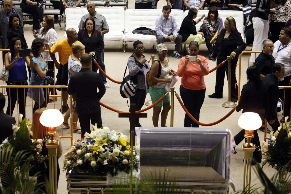 Mourners line up to pay their last respects to Cheo Feliciano during his funeral at the San Juan Coliseum in Puerto Rico, Saturday April 19, 2014. Feliciano, a member of the Fania All Stars died in a car crash early Thursday morning when he hit a light post before dawn in the northern suburb of Cupey in San Juan. (AP Photo/Ricardo Arduengo)