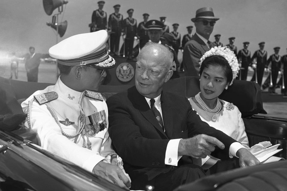 In this June 28, 1960, file photo, U.S. President Dwight Eisenhower, center, is seated between Thailand's King Bhumibol Adulyadej, left, and Queen Sirikit for a motorcade drive from National Airport to the White House in Washington.