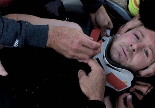 Pain shows in Andrew Cotton's eyes as he's strapped to a stretcher. (Photo: Andrew Cotton/Instagram)