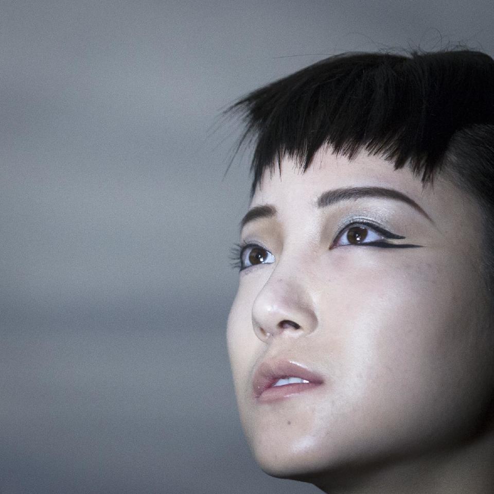 Model Shie Wang, of China, poses for a photograph backstage before the Carmen Marc Valvo Fall 2014 collection is modeled during Fashion Week, Friday, Feb. 7, 2014, in New York. (AP Photo/John Minchillo)