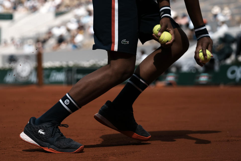 A ballboy collects the tennis balls on Philippe Chatrier court during Stefanos Tsitsipas of Greece playing against Spain's Pablo Carreno Busta fourth round match on day 8, of the French Open tennis tournament at Roland Garros in Paris, France, Sunday, June 6, 2021. (AP Photo/Thibault Camus)